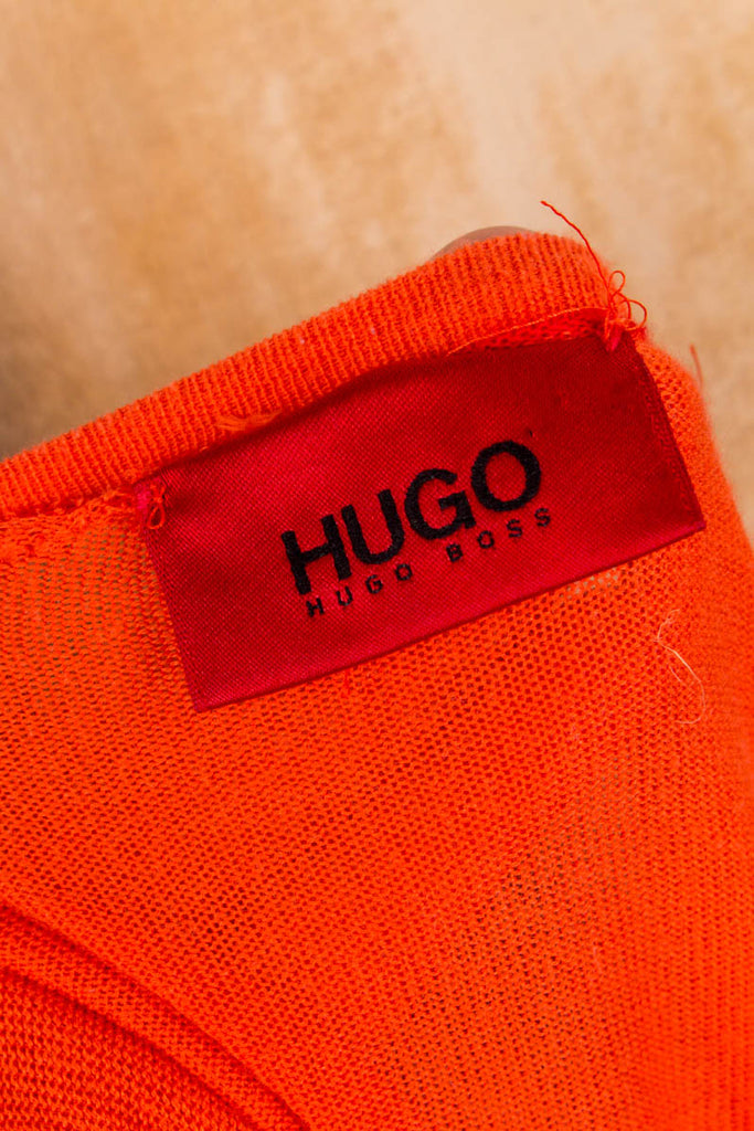 leichte Strickjacke aus Ausschnitt, V- weichem Baumwollstrick orangefarbenem Bündchen Knopfleiste, mit